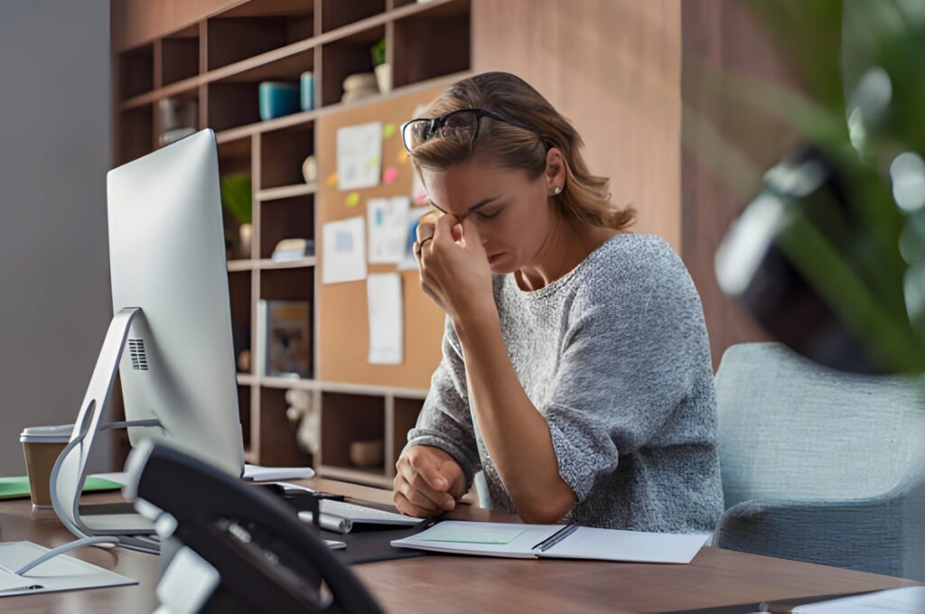 "Stressed event planner looking at a laptop with a 'Fully Booked' December calendar, symbolizing the frantic, limited choices of late holiday party planning."